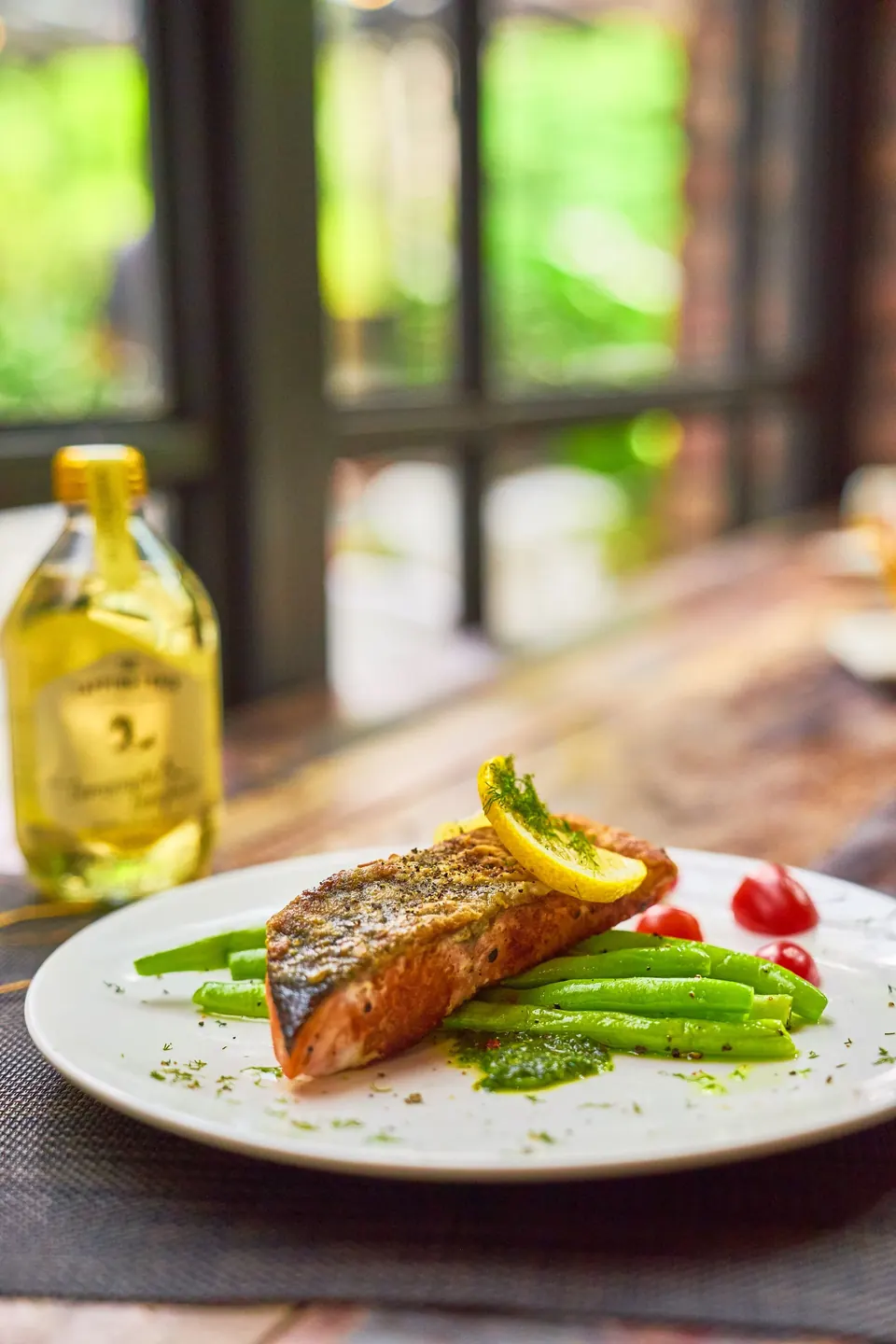 Roasted salmon with green beans and lemon in warm window light