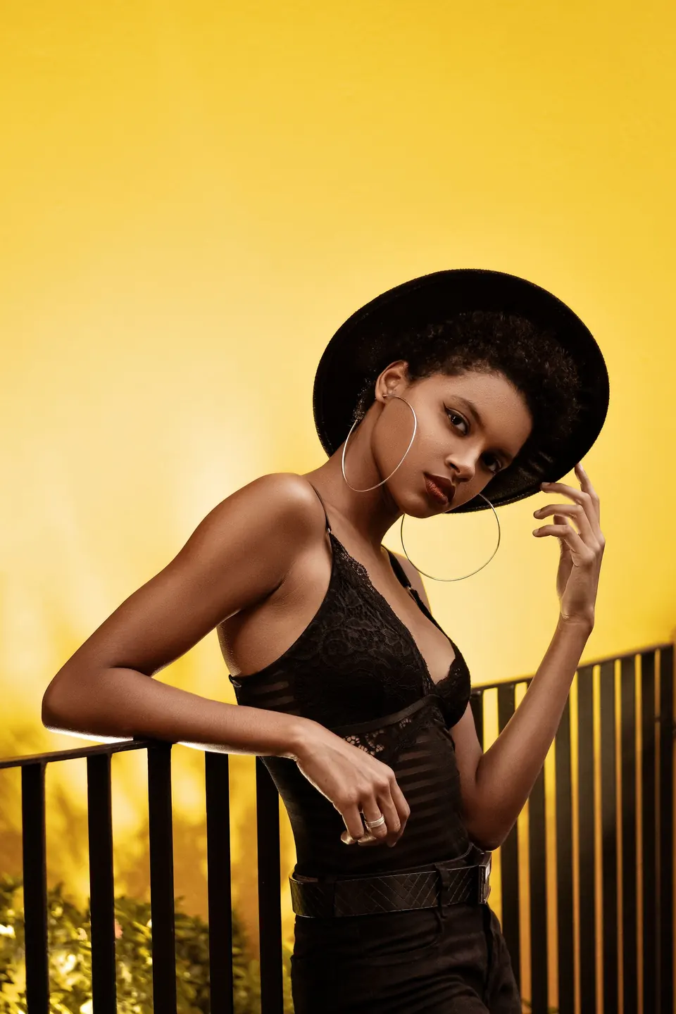 Woman in a black hat on a balcony at golden hour