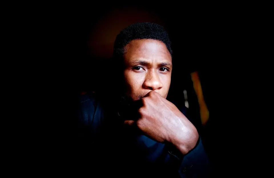 Low-key portrait of a man resting his chin on his hand